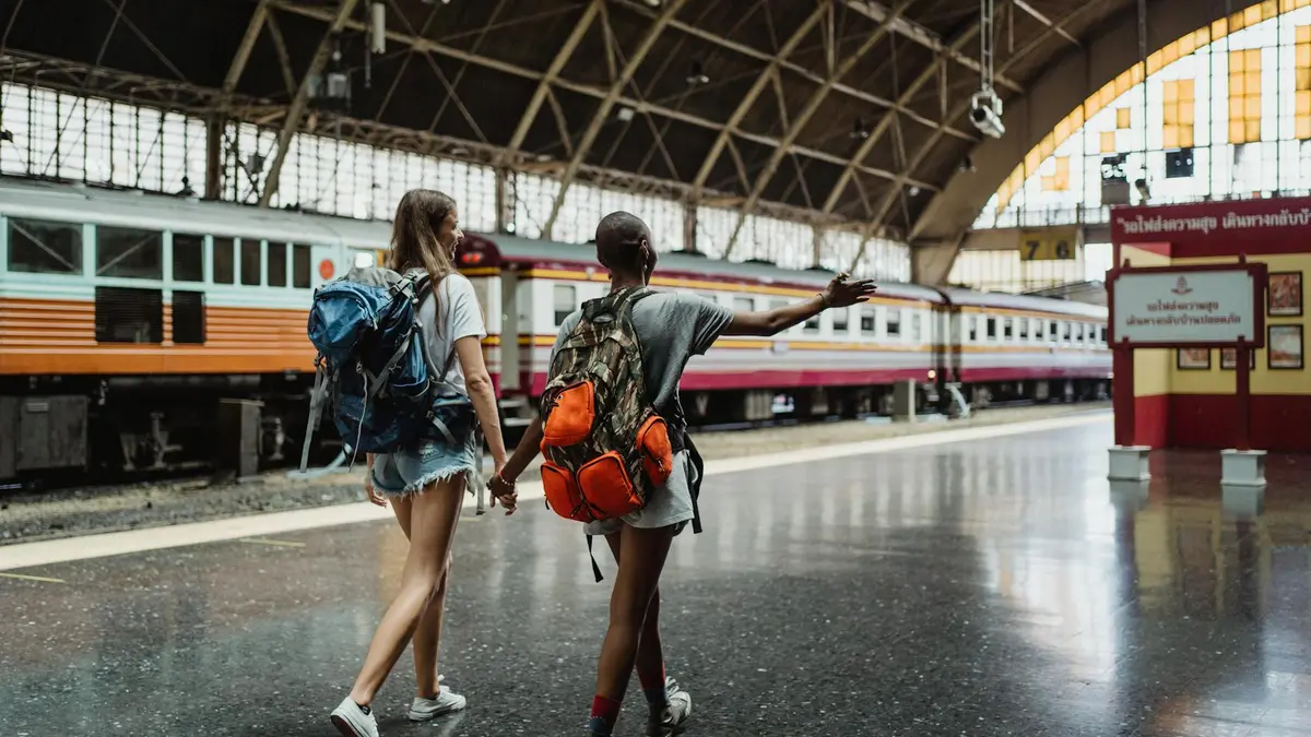 Pasajera con mochila en el andén esperando un tren Interrail por Europa